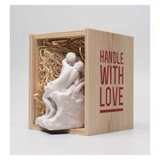 White miniature stature of a couple kissing in a wooden crate