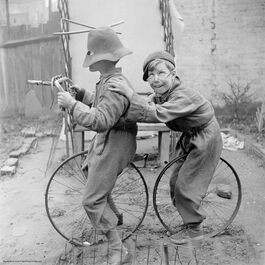 Nigel Henderson: Two unidentified children playing with bicycle wheels