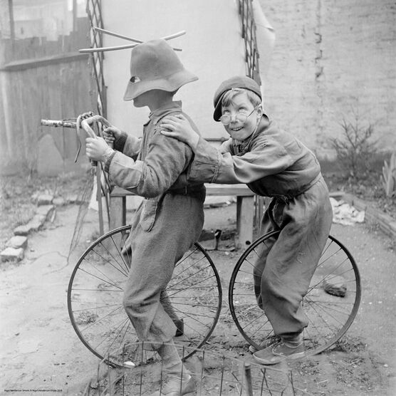 Nigel Henderson: Two unidentified children playing with bicycle wheels