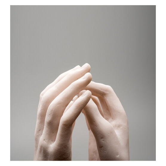 Miniature sculpture replica of two intertwined hands detail