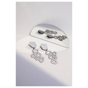 silver leather earrings, laying flat next to a mirror