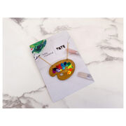 Wooden paint pallete necklace with paint splotches on card