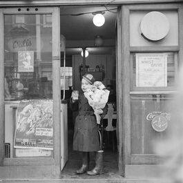 Nigel Henderson: Unidentified boy in a doorway with flowers