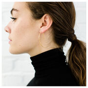 Gold hammered metal earrings in a crescent shape on model