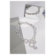 Silver leather necklace laying flat next to a mirror