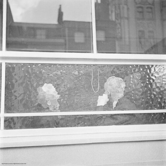 Nigel Henderson: Heads seen through pub window, East End