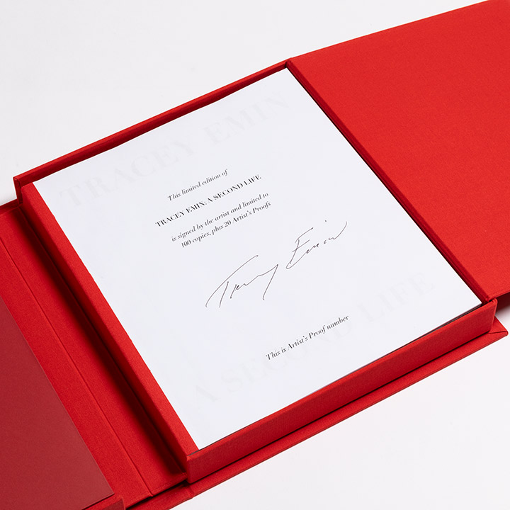 Red clothbound altar-style book open to show artist signature page