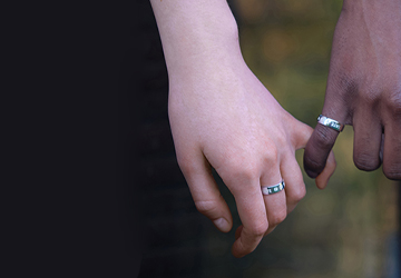 Two models holding hands together, showcasing silver ring band on each hand