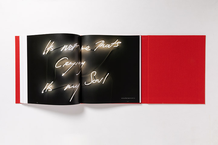 Red clothbound altar-style book open to show a neon artwork spread that reads It's Not Me Crying It's My Soul